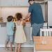 Father and children cooking together in a modern kitchen, enjoying family time.